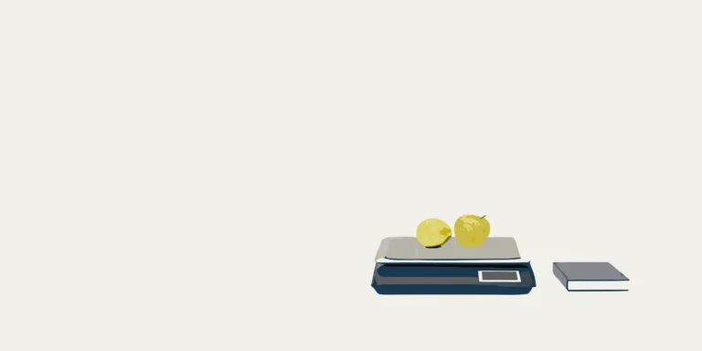 ACS series price computing scale weighing apples next to its user manual in español.